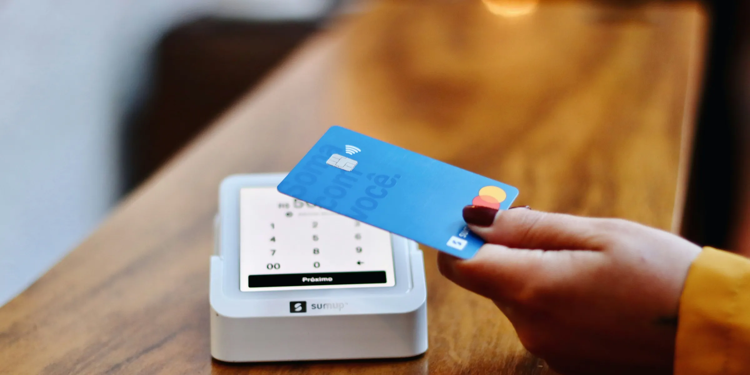 a person holding a credit card in front of a machine