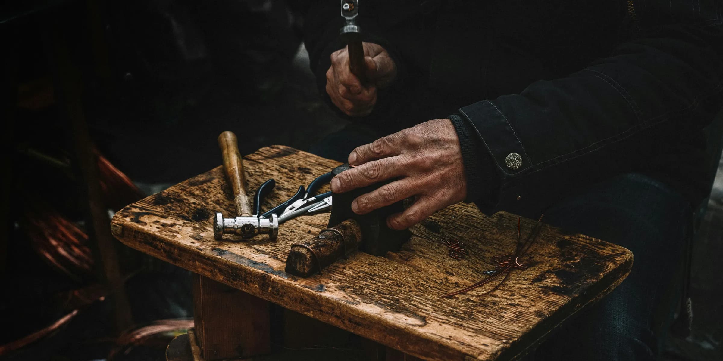 a man is using a pair of scissors to cut a piece of wood
