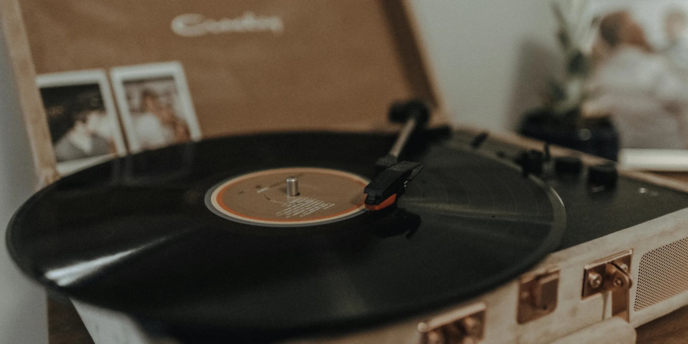 black vinyl record on brown portable turntable