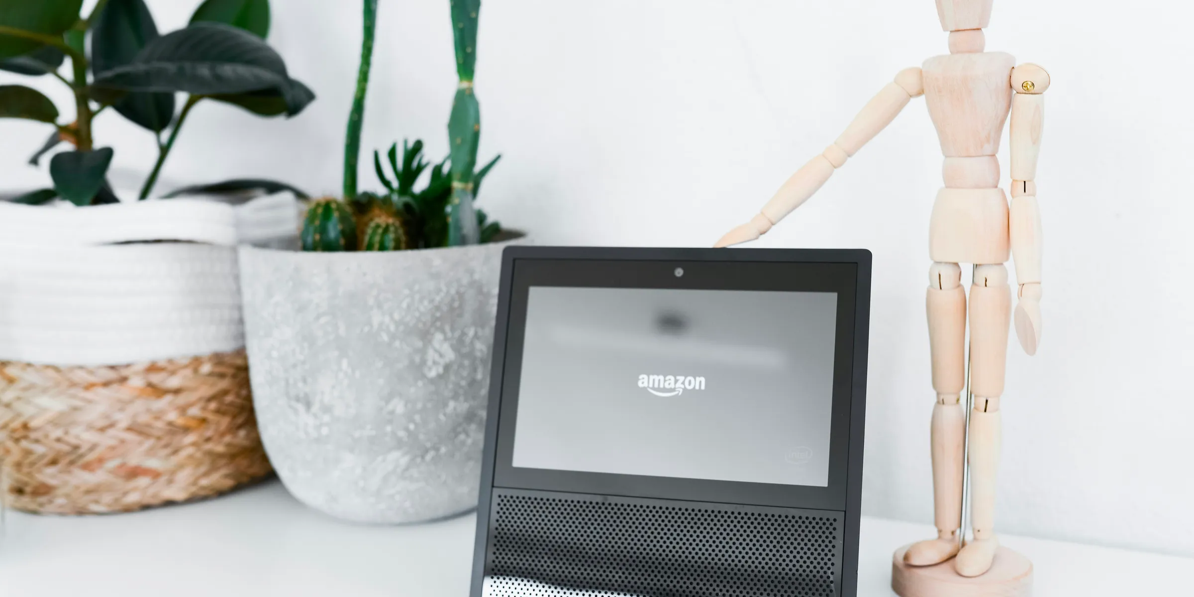 white mannequin miniature near Amazon tablet on table