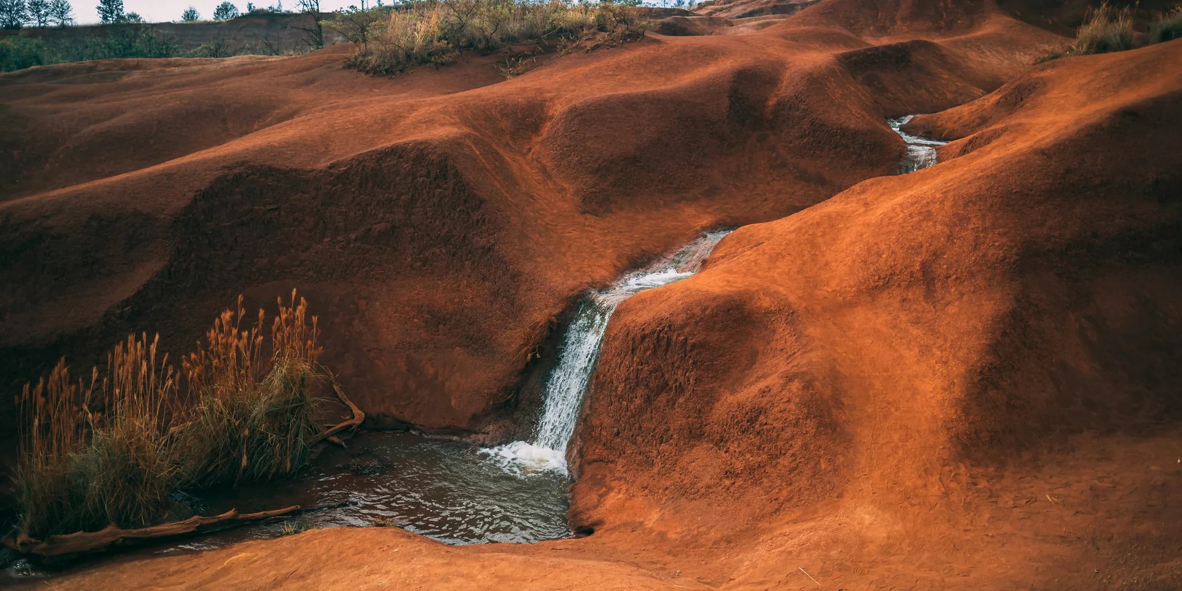 water flowing on brown hill