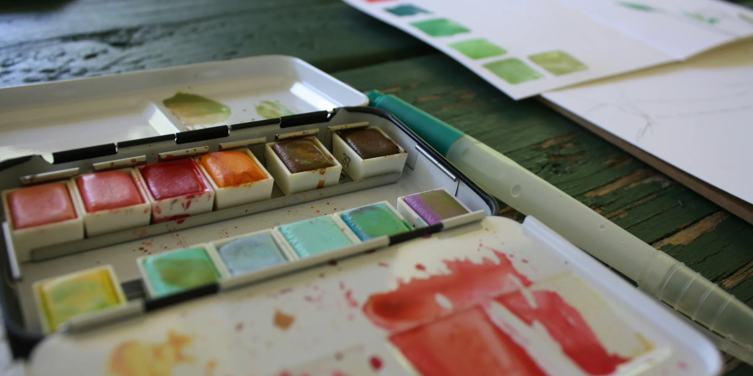 A close up of a palette of watercolors on a table