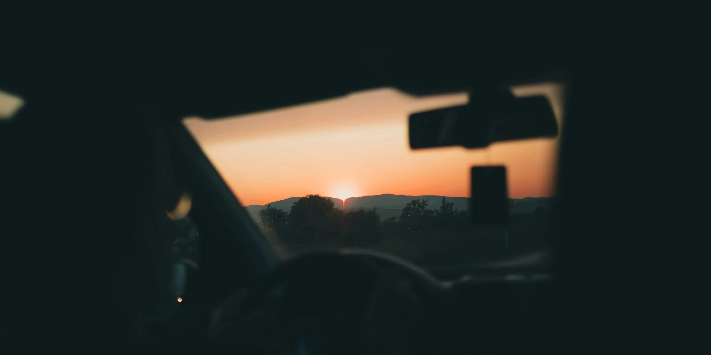 person in car seeing sunset