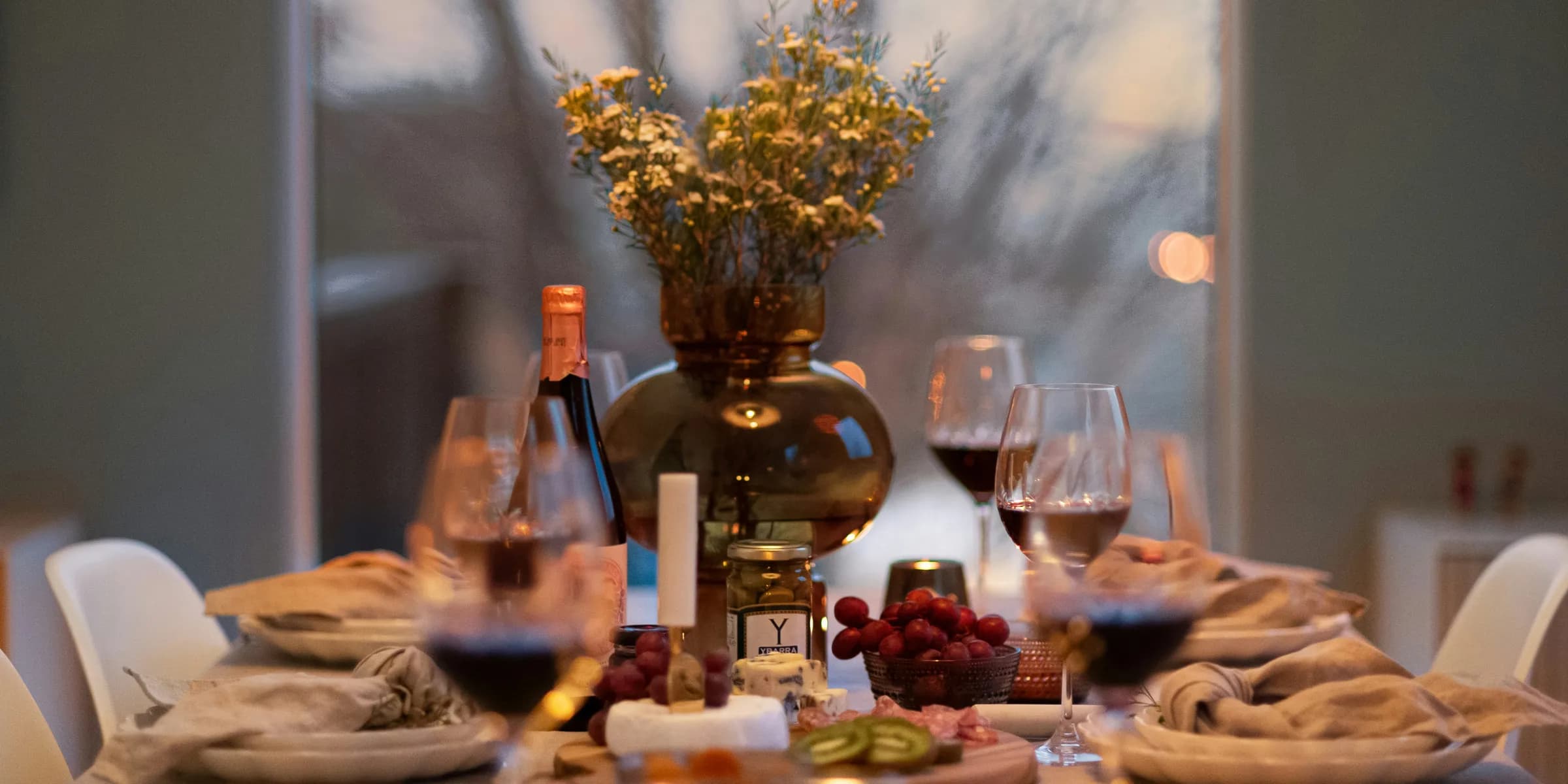 A dinner table with wine glasses and plates of food