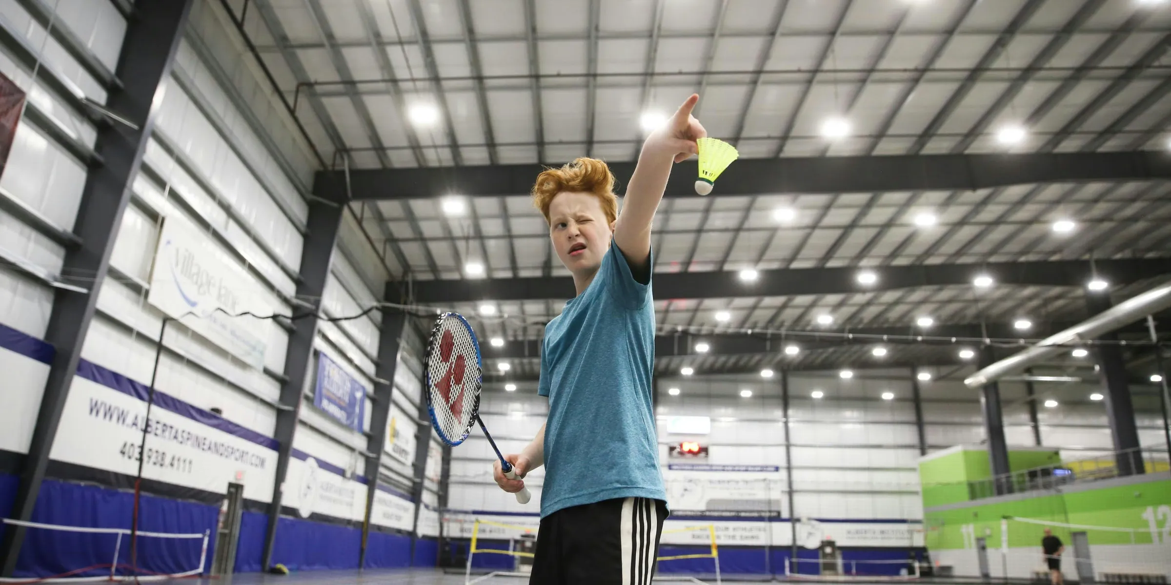boy about to serve a badminton shuttle cock